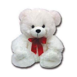 A white teddy bear with red bow sitting on top of it.