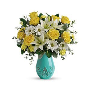 A bouquet of yellow roses and white flowers in a turquoise vase.