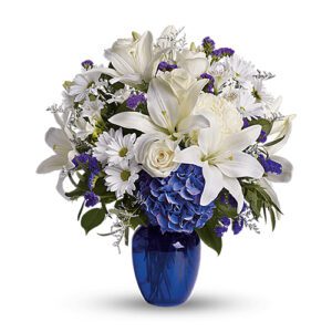 A blue vase filled with white flowers.