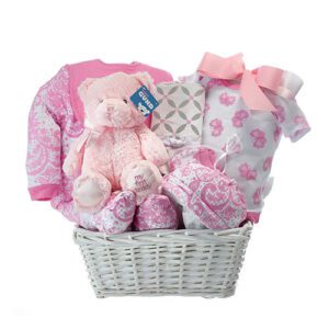 A basket of baby girl clothes and toys.