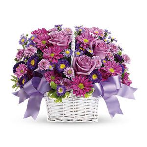 A basket of flowers with purple ribbon