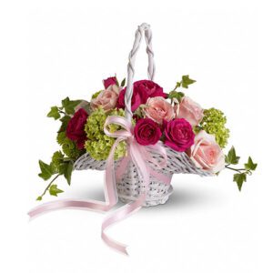 A basket of flowers with pink roses and green leaves.