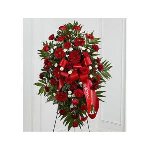 A red funeral flower arrangement with white flowers.
