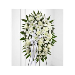A white funeral bouquet with roses and other flowers.