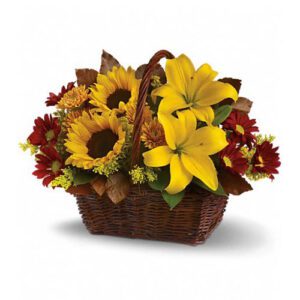 A basket of flowers with sunflowers and red carnations.