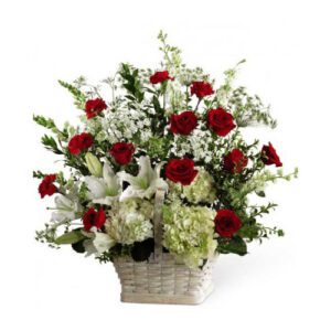 A basket of flowers with red roses and white flowers.
