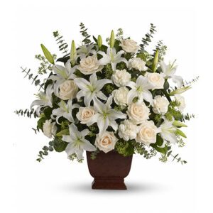 A bouquet of white flowers in a brown vase.