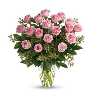 A vase filled with pink roses on top of a table.