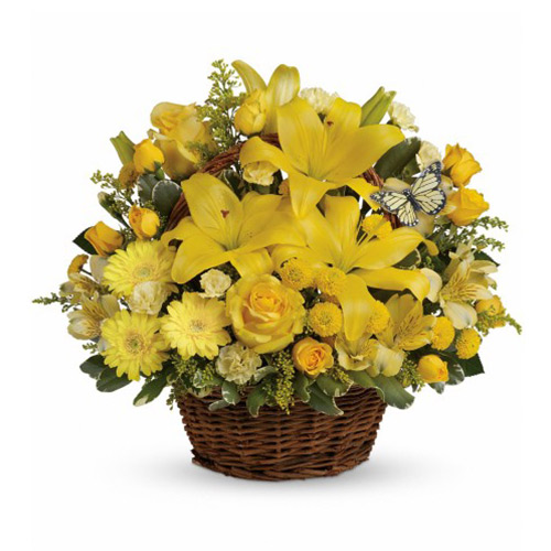 A basket of yellow flowers on top of the floor.