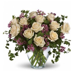A bouquet of white roses and purple flowers in a vase.