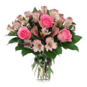 A vase filled with pink flowers on top of a table.