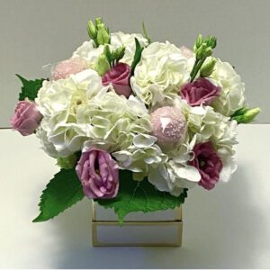 A bouquet of flowers in a square vase.