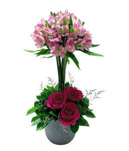 A bouquet of flowers in a vase with two roses.