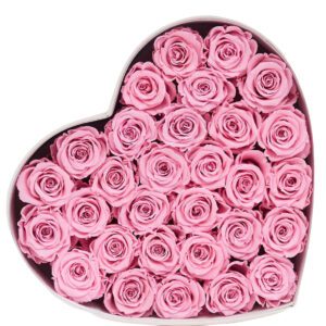 A heart shaped box filled with pink roses.