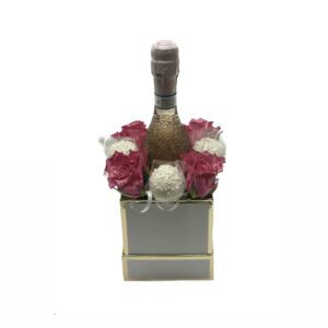 A bottle of wine in a box with flowers.