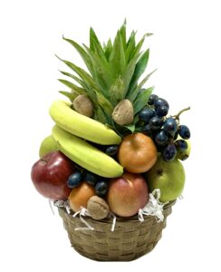 A basket of fruit with bananas, apples and other fruits.