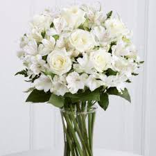 A vase filled with white flowers on top of a table.