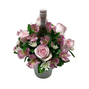 A bouquet of flowers in a vase with a wine bottle.