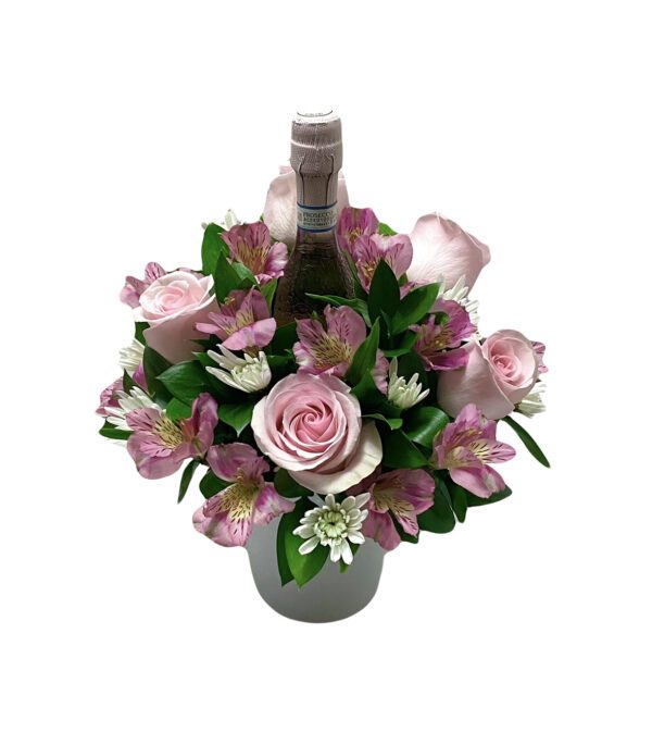 A bouquet of flowers in a vase with a wine bottle.