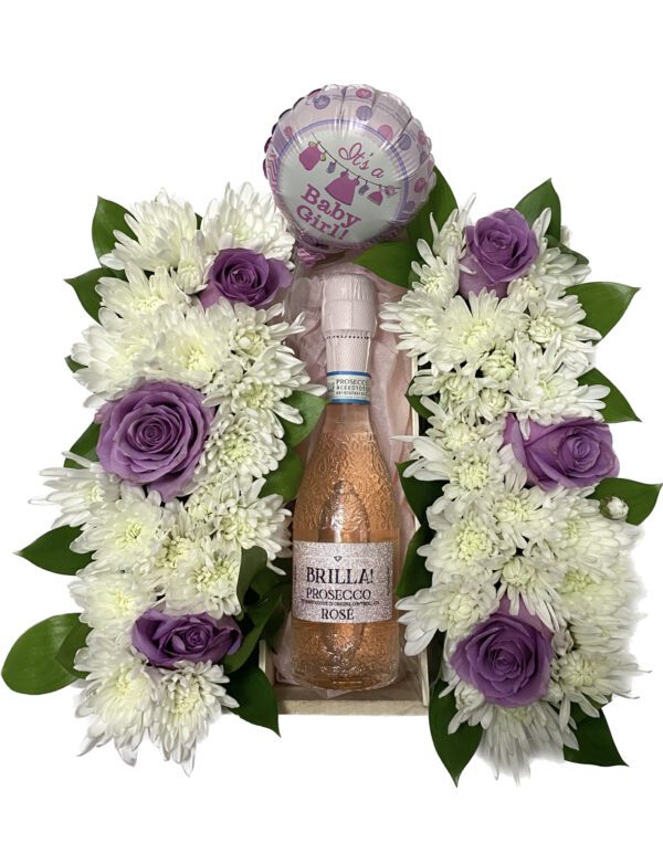 A bottle of wine and flowers are arranged in a floral arrangement.