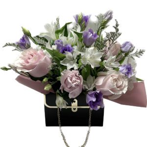 A bouquet of flowers in a black purse.