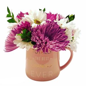 A pink mug with flowers inside of it