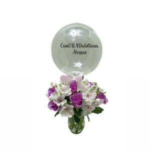 A vase filled with flowers and a balloon.