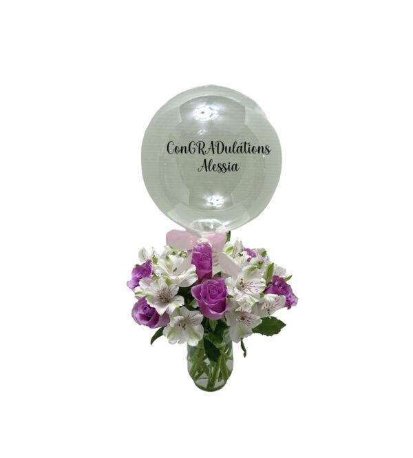 A vase filled with flowers and a balloon.