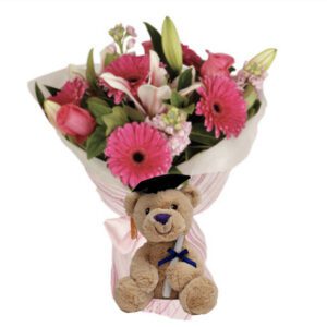 A teddy bear with flowers in it