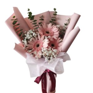 A bouquet of flowers wrapped in paper with pink and white flowers.