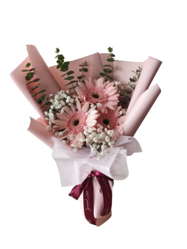 A bouquet of flowers wrapped in paper with pink and white flowers.