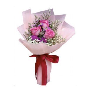 A bouquet of flowers wrapped in paper with red ribbon.